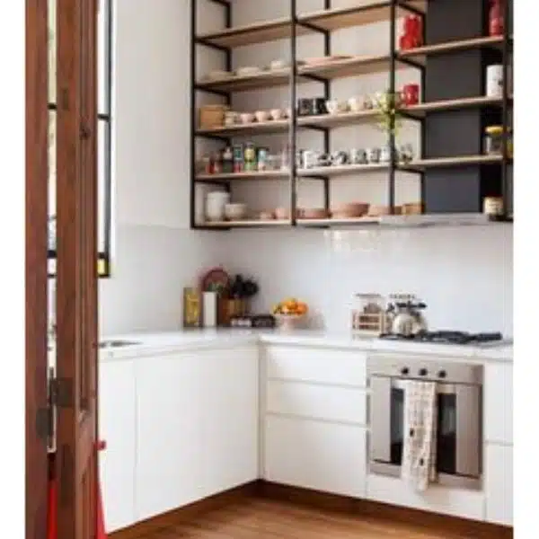 Cocina moderna con estantes abiertos, encimeras blancas y horno de acero inoxidable.