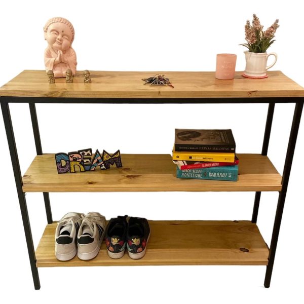 Estante de madera con libros, tenis, una figura de Buda, decoración y plantas.