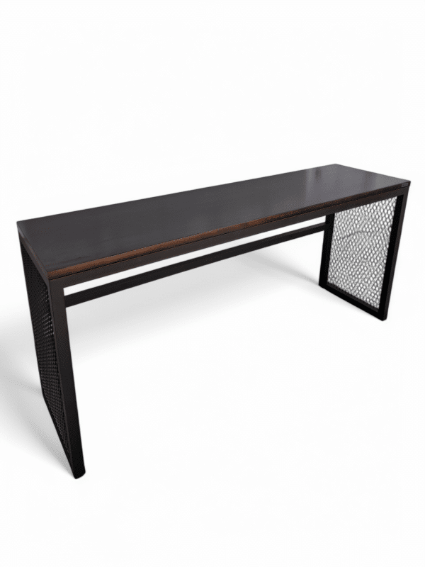 Mesa rectangular de madera oscura con diseño moderno y minimalista, patas laterales metálicas con patrón de rejilla que añaden un toque industrial. Superficie lisa y elegante.