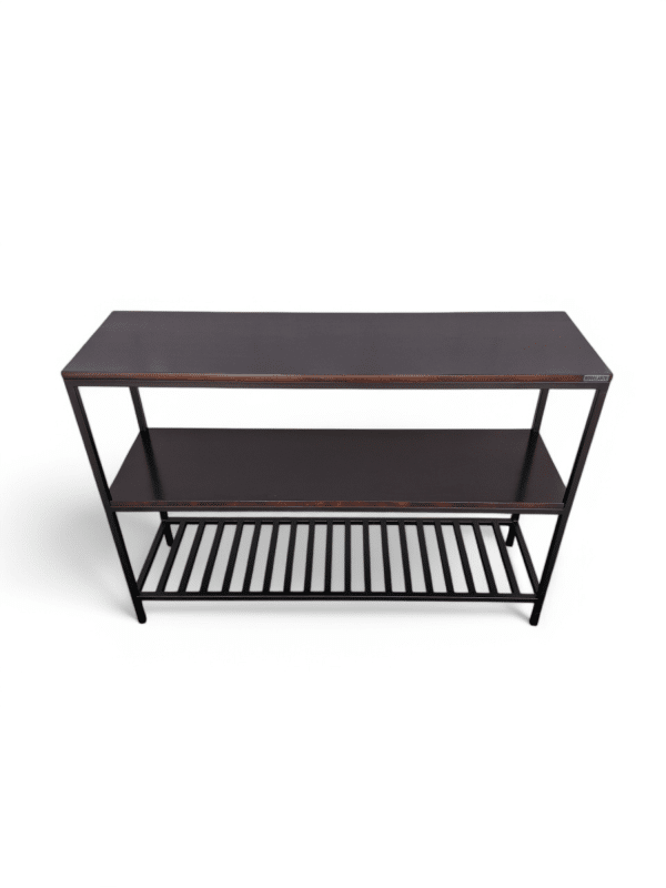 Mesa rack auxiliar moderno de madera oscura con estructura metálica negra. Tiene un estante inferior con rejillas, ideal para almacenaje. Diseño minimalista y funcional para espacios contemporáneos.