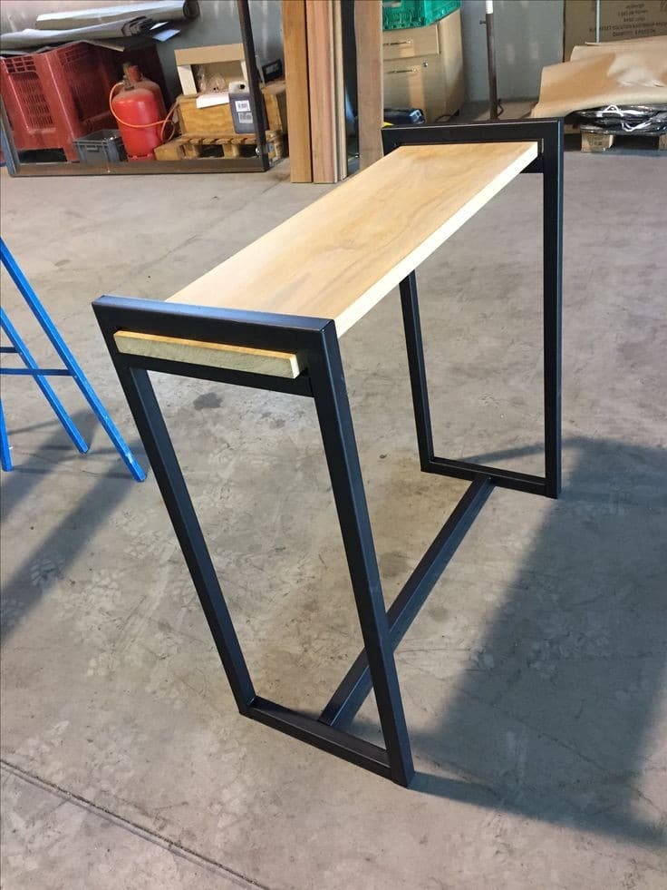 Mesa auxiliar de madera con estructura metálica negra, ideal para espacios modernos. Útil como consola de entrada o mueble decorativo en salas de estar o pasillos estrechos.