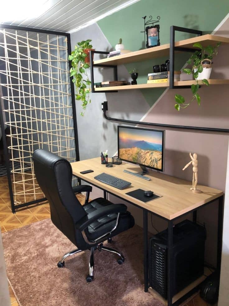 Escritorio moderno con superficie de madera y estructura metálica, equipado para trabajo en casa; incluye silla ergonómica, estantería con plantas y accesorios decorativos. Ideal para productividad.