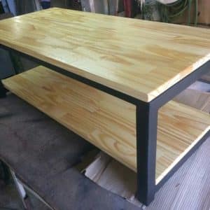 Mesa de centro estilo industrial, madera clara y estructura metálica negra. Ideal para sala de estar, combina almacenamiento y diseño moderno.