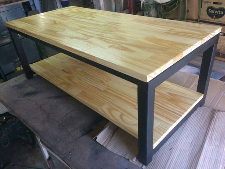 Mesa de centro estilo industrial, madera clara y estructura metálica negra. Ideal para sala de estar, combina almacenamiento y diseño moderno.