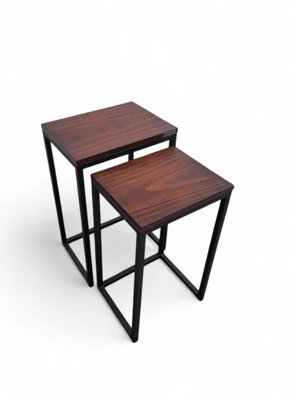 Mesitas nido con tablero de madera oscura y estructura metálica negra. Ideal para salas pequeñas, permiten ahorrar espacio al usarse juntas o por separado. Perfectas para libros o decoración.