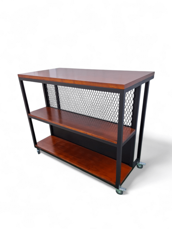 Mesa de madera con estructura metálica y ruedas; ideal como desayunador para cocina. Ofrece dos repisas para almacenamiento, combinando funcionalidad y estilo industrial.