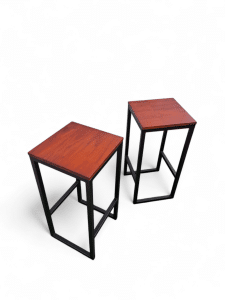 Dos bancos altos con asientos de madera y estructura metálica negra, ideales para barra desayunador. Diseño moderno y funcional para optimizar el espacio en cocinas pequeñas.
