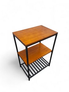 Mesita de madera con estructura metálica, ideal como revistero. Incluye dos estantes y una rejilla inferior para organizar revistas y periódicos en el salón.