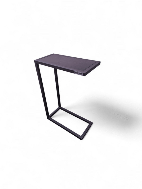 Mesita de sillón oscura con estructura metálica minimalista, ideal para sostener libros, bebidas o dispositivos mientras se descansa cómodamente. Perfecta para espacios modernos y funcionales.