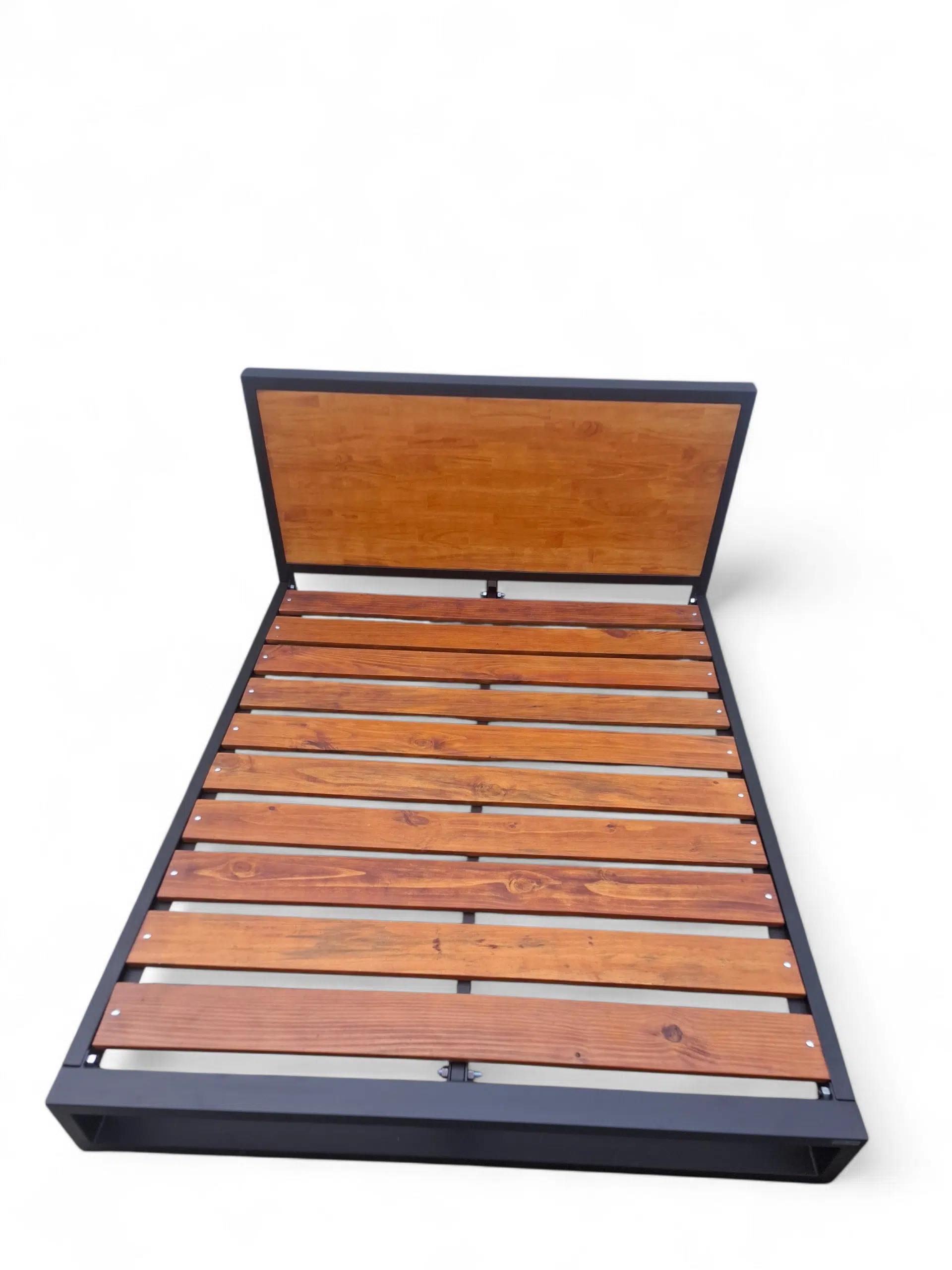 Cama de hierro y madera estilo industrial, estructura robusta y elegante, ideal para dormitorios modernos. Diseño minimalista con cabecera de madera clara y base de metal negro.