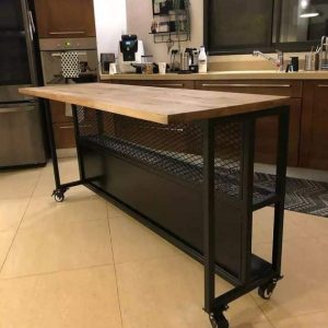 Mesa de cocina móvil con superficie de madera y estructura metálica negra, incluye ruedas para fácil desplazamiento y estante inferior de rejilla para almacenamiento adicional.
