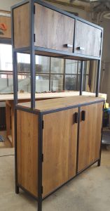 Gabinete moderno de madera con estructura metálica negra. Cuenta con dos puertas superiores y dos inferiores, ideal para almacenamiento en espacios contemporáneos.