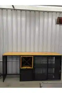 Gabinete metálico con encimera de madera, estructura negra con estantes de malla y un espacio en forma de cubo. Ideal para organización en talleres o garajes.