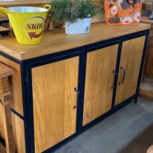 Un mueble de madera con estructura metálica negra, cuenta con tres puertas y tiradores oscuros. Ideal para almacenamiento en espacios contemporáneos o rústicos.