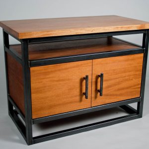 Mueble de madera con estructura de metal negro, incluye una superficie amplia y dos puertas con tiradores oscuros. Diseño moderno y robusto, ideal para almacenamiento y decoración interior.