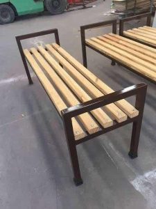 Banco de madera y metal con diseño simple. Estructura robusta de metal oscuro y asiento de listones de madera clara. Ideal para ambientes exteriores o interiores.