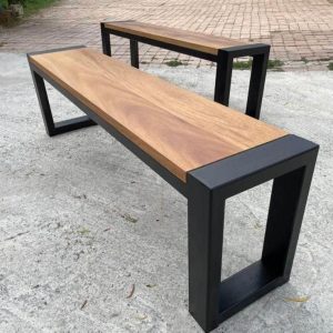 Banco moderno de madera con base de metal negro, diseño minimalista, ideal para interiores o exteriores, combina calidez natural con un estilo industrial contemporáneo.
