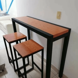 Mesa alta de madera con estructura metálica negra, acompañada de dos taburetes a juego con diseño minimalista, ideal para espacios modernos.