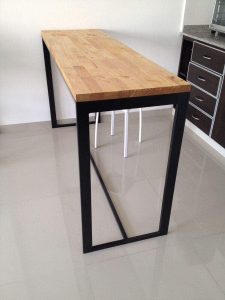 Mesa alta con tablero de madera clara y estructura metálica negra. Diseño minimalista ideal para cocinas contemporáneas.