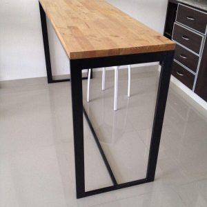 Mesa alta con tablero de madera clara y estructura metálica negra. Diseño minimalista ideal para cocinas contemporáneas.