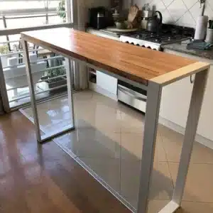 Mesa alta moderna con tablero de madera y estructura metálica geométrica en una cocina, ideal como barra de desayuno o espacio de trabajo funcional y estilizado.
