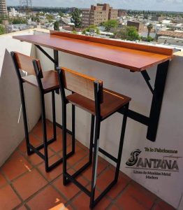 Barra de madera con dos sillas altas, estructura metálica negra. Diseño minimalista y funcional, ideal para espacios pequeños o balcones.