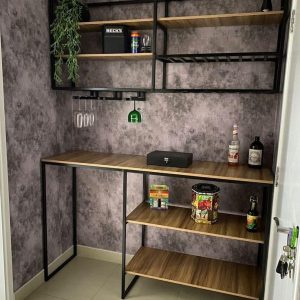 Estante de bar en esquina con estructura negra y superficies de madera. Incluye estantes altos, espacios para botellas y copas colgantes, ideal para almacenamiento moderno.