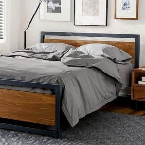 Cama moderna con marco de metal negro y paneles de madera. Diseño minimalista, elegante y funcional, ideal para dormitorios contemporáneos.