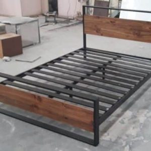 Cama individual con estructura de metal negro y detalles de madera en el cabecero y piecero, ideal para dormitorios modernos y minimalistas.