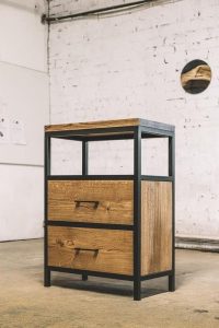 Mueble moderno industrial con marco de metal negro y cajones de madera en tonos cálidos. Diseño robusto y funcional con un aire minimalista. Adecuado para almacenamiento en interiores.