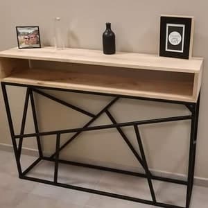 Mesa consola moderna con estructura metálica negra geométrica y tablero de madera clara. Diseño minimalista y elegante, ideal para entradas o salas de estar.