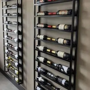 Estantería vertical de metal negra para botellas de vino, montada en la pared. Diseño moderno y minimalista con múltiples niveles horizontales para almacenamiento eficiente.