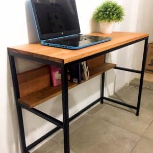 Escritorio de madera con estructura metálica negra, estante inferior integrado y superficie despejada, ideal para oficinas modernas o espacios de estudio compactos.