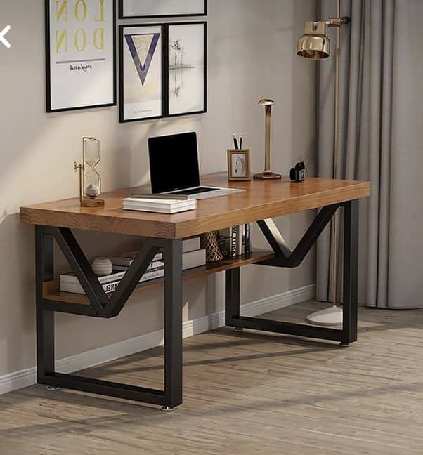 Escritorio moderno con tablero de madera clara y patas metálicas negras en forma de V. Incluye estante inferior para almacenamiento. Ideal para oficina o estudio, combinando función y estilo.