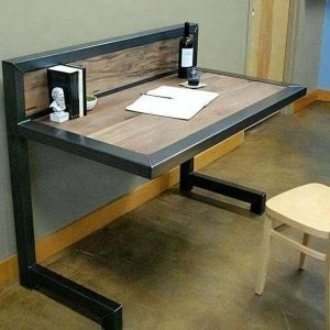 Escritorio minimalista suspendido con estructura de metal negro y superficie de madera. Cuenta con un respaldo elevado y un soporte en forma de L. Diseño elegante y moderno.