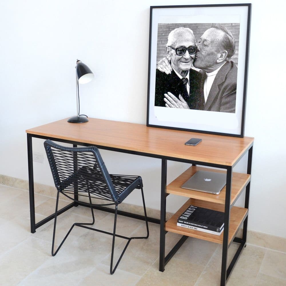 Escritorio minimalista de madera clara con estructura metálica negra, dos estantes laterales, y una silla moderna de diseño en negro.