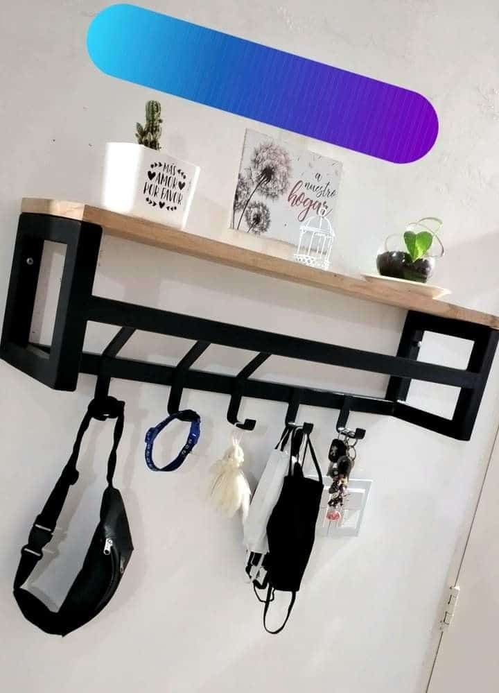 Estante de pared con repisa de madera, estructura de metal negro, cinco ganchos para colgar objetos. Moderno y funcional para decoración y organización del hogar.