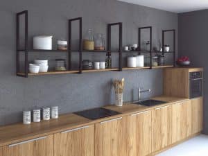 Cocina moderna con encimeras y gabinetes de madera clara, estanterías abiertas negras, y pared gris. Diseño minimalista y funcional, con electrodomésticos integrados.