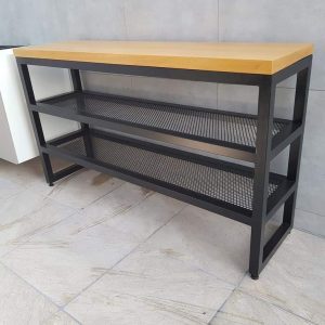 Mesa consola moderna de estructura metálica negra con dos estantes de rejilla y superficie superior de madera clara, ideal para decoración de interiores o almacenamiento.