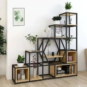 Estantería modular escalonada con estructura de metal negro y baldas de madera clara. Exhibe plantas y decoraciones, ideal para espacios modernos y minimalistas.