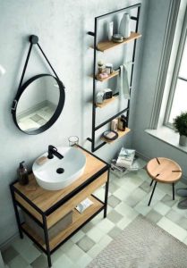 Mueble de baño minimalista con lavabo blanco sobre encimera de madera, estante inferior abierto, estructura de acero negro, complementado con estante vertical con baldas de madera.