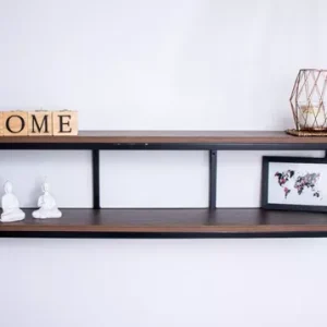 Estante flotante de dos niveles en madera oscura con marco negro. Decorado con letras HOME, figuras blancas, una vela en jaula metálica y un cuadro pequeño.