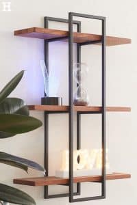 Estantería de pared moderna con estructura de metal negro y tres baldas de madera; ideal para exhibir decoraciones o libros. Diseño minimalista y elegante para el hogar.