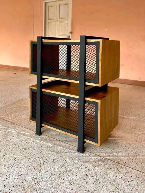 Estantería de diseño industrial con estantes de madera y estructura metálica negra. El mueble cuenta con paneles de rejilla, ideal para almacenamiento moderno y decorativo.