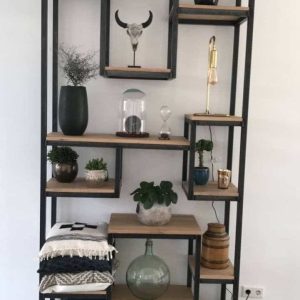 Estantería alta de madera con marco metal negro, múltiples estantes decorados con plantas, libros y objetos diversos, ideal para salas modernas.