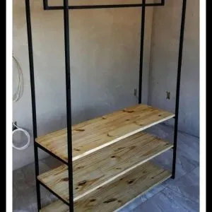 Estante minimalista de madera con estructura metálica negra, tres niveles amplios para almacenamiento y barra superior para colgar, ideal para organización y decoración moderna.
