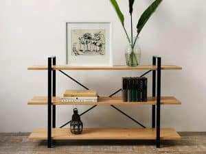 Estantería moderna de madera clara con tres niveles y soporte metálico negro, ideal para decoración y almacenamiento en interiores.