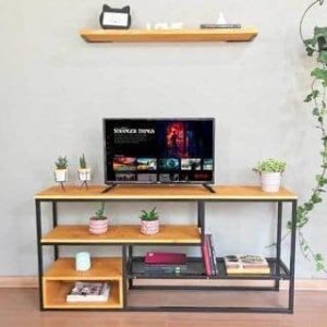 Mueble de TV moderno con estantes de madera y estructura metálica negra, decorado con pequeñas plantas y libros.