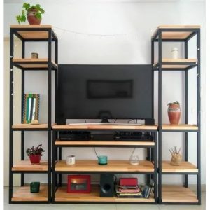 Estante de TV de metal negro y madera, con múltiples niveles para almacenamiento. Cuenta con plantas y objetos decorativos, ideal para una sala moderna y funcional.