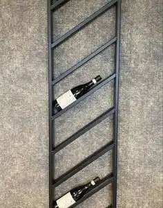 Estante de vino vertical de metal negro, diseño minimalista con compartimentos inclinados para botellas, montado en la pared sobre fondo gris.
